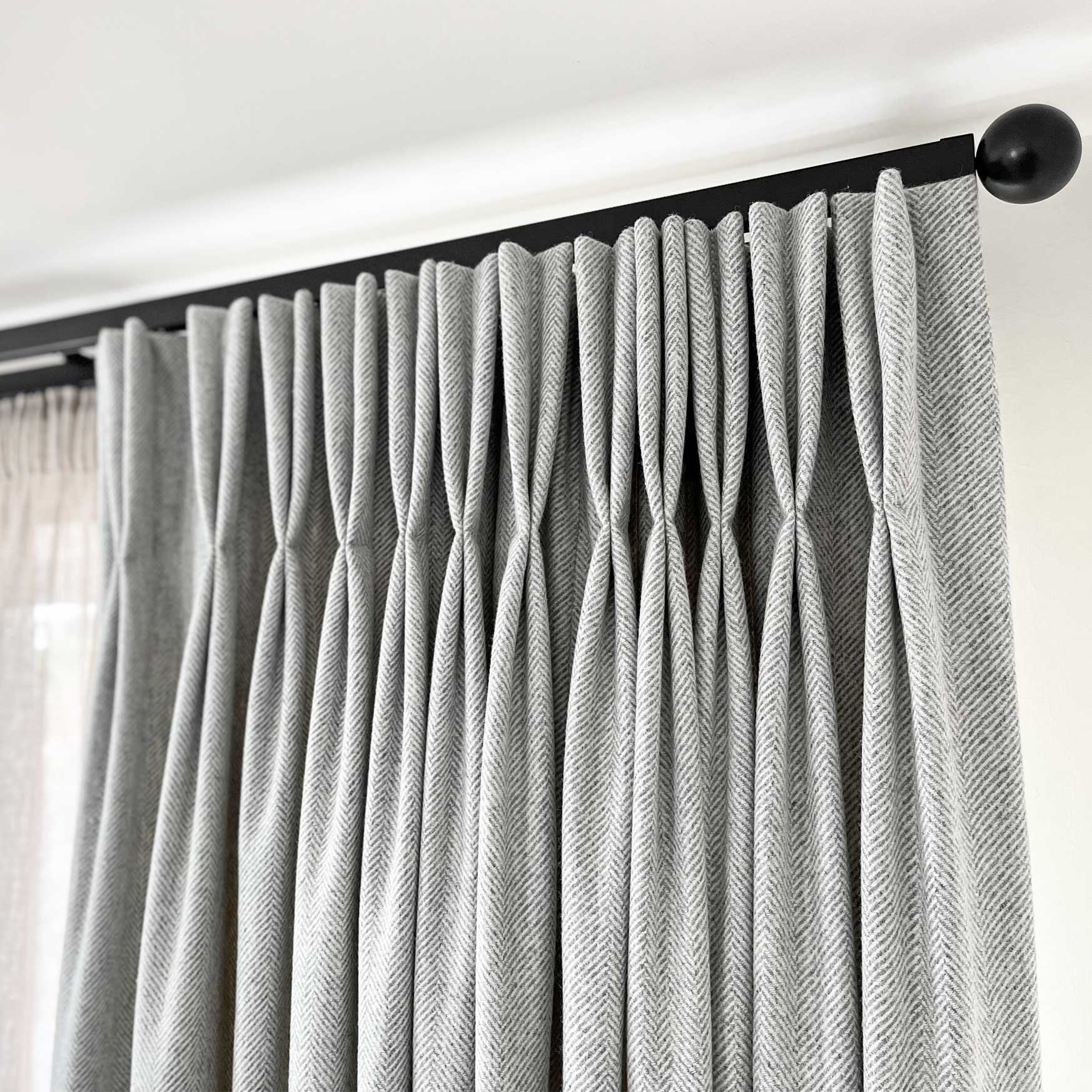 Square30 double curtain track with heavy wool curtain featuring handsewn double pinch pleat heading and linen sheer curtain behind.