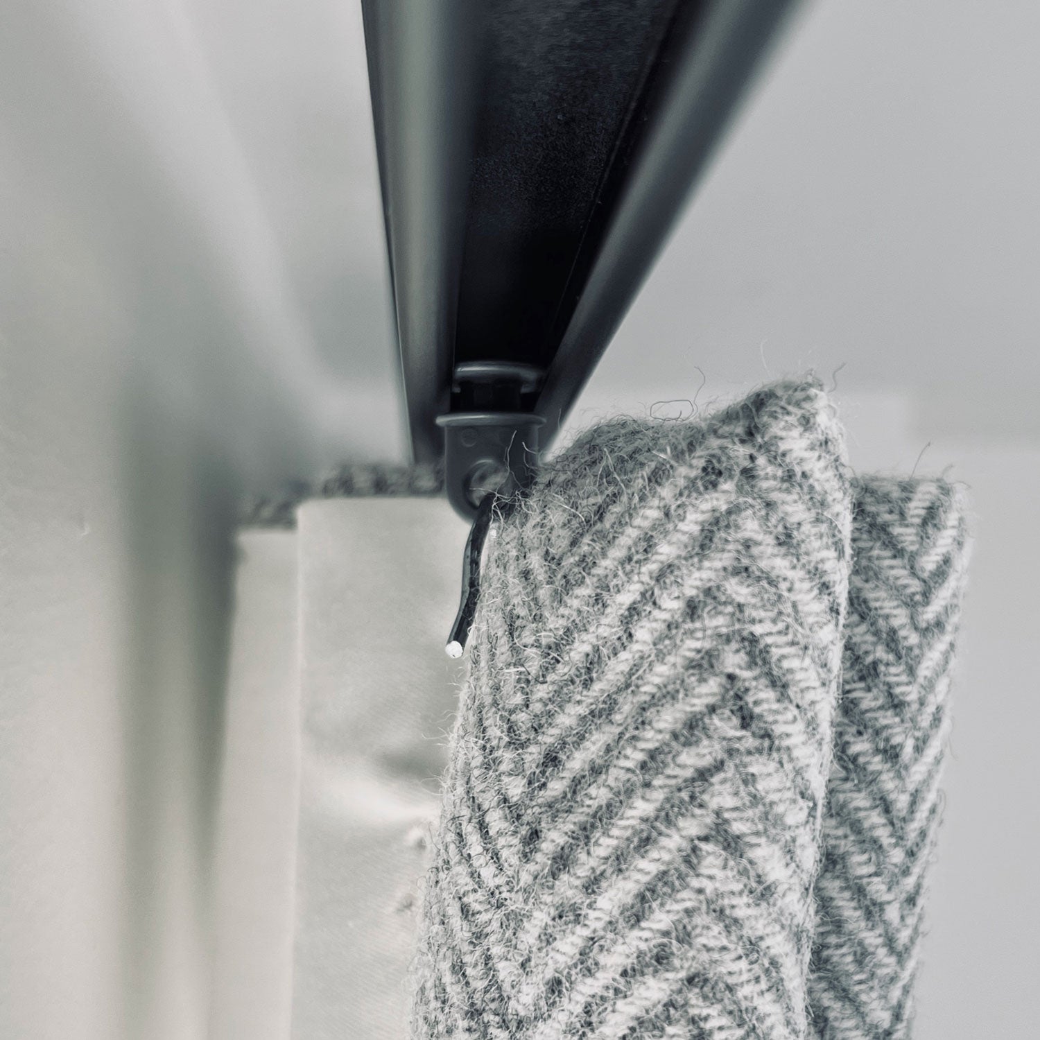 Detail of the curtain hook on a glider for double pleat headed wool curtains